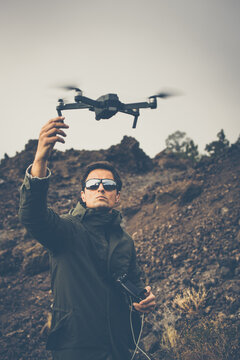 Young man with a drone outdoors, flying in windy conditions