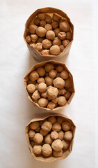 Edible caramel clay stones in brown bags on a white background