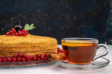 a front view round honey cake delicious and baked with red cranberries and tea on the grey desk cake biscuit sugar sweet photo