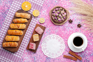 Fototapeta na wymiar top view cup of tea with marmalade pieces and bagels on pink background sweet sugar tea lemon color
