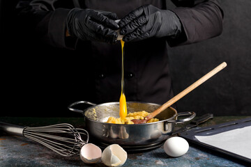 Cracking raw eggs into a bowl for making a cake