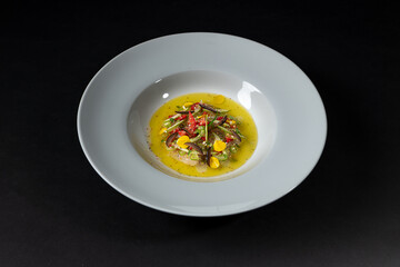 Close up of a plate of Gourmet and gastronomic mix of various Vegetables ingredients isolated on a black background, entree dish