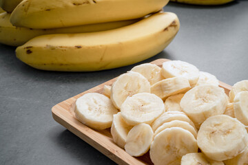 Banana slices and banana curls on the stone table.
