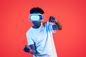 African american guy gamer enjoying virtual reality experience on red