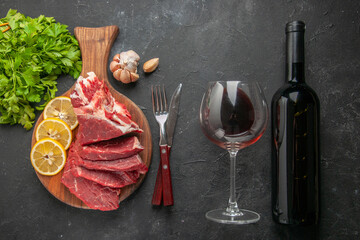 top view fresh sliced meat with greens and lemon slices on dark background animal food barbecue butcher dinner meal cooking meat wine