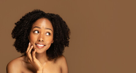 Excited cheerful half-naked black woman looking at copy space