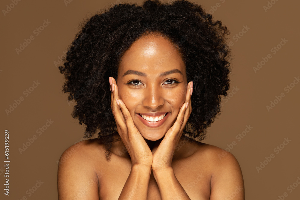 Wall mural beautiful young black woman touching her pretty face and smiling