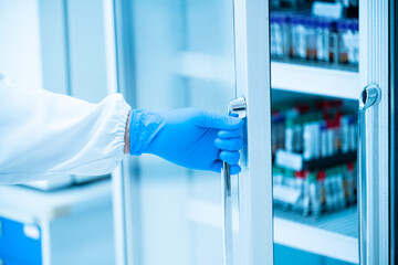 Close up scientist hand wear blue gloves opening storage reagent container for laboratory...