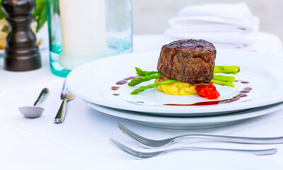 Beef steak on the plate on the table,Grilled Porterhouse or T-Bone Steak Served with golden fries and fresh herb salad with BBQ or tomato sauce.