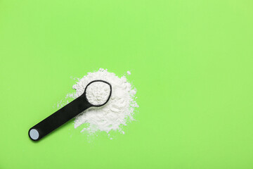 Scoop of amino acid supplement on green background
