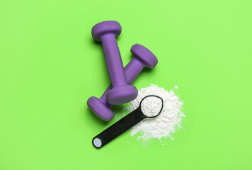 Scoop of amino acid supplement and dumbbells on color background