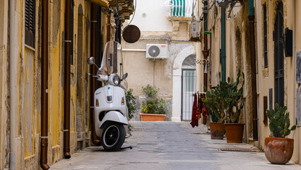 Old scooter parked in a typical Italian narrow street ,IT is an old motor bike of the city siracusa, sicily © nehuen