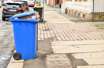 Fototapeta na wymiar Garbage containers with trash on city street