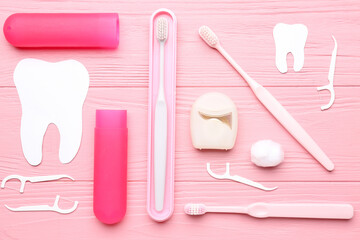 Composition with dental floss, toothpicks and brushes on pink wooden background