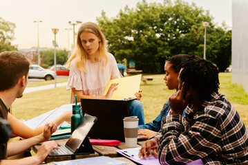 Fototapeta premium multiracial group of young man and women studying together outside of university campus. college lifestyle.