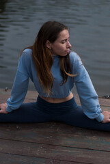 Fototapeta na wymiar Young girl is doing yoga outdoors