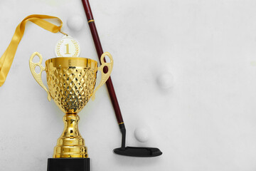 Gold cup with golf club and balls on white background