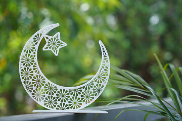 Beautiful crescent moon shape isolated on green background, Eid Mubarak photo