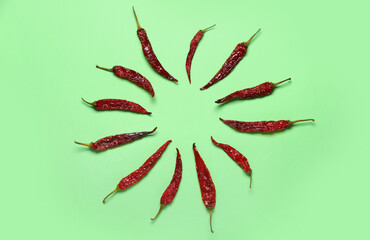 Frame made of dry chili peppers on pale green background