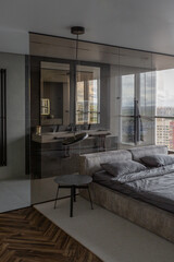cool expensive interior design of room in prestigious luxury hotel with dark tones with modern LED lighting and stylish furniture. the area with a sink is separated by dark glass from the bedroom