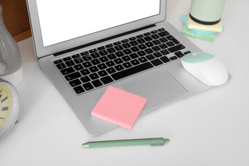 Laptop with sticky notes on white table