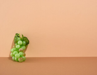 Green bunch of ripe, juicy grapes near the wall. Copy space for text.