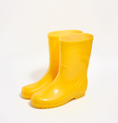 Bright yellow rubber boots for agricultural work isolated on white background. Spring garden works.