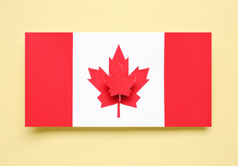 Paper flag of Canada with maple leaf on yellow background