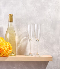 Colorful date. A bottle of white wine and two glasses. Yellow beautiful flowers.