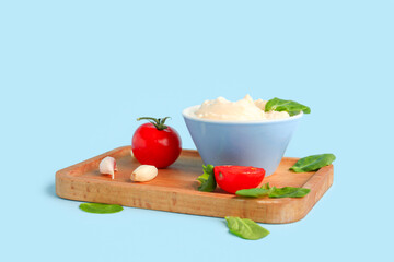 Bowl with tasty cream cheese on blue background