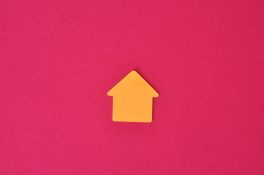 símbolo casa amarela pequena em fundo rosa, negócios imobiliários 