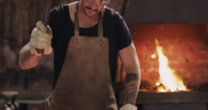 Hammer, iron and and steel worker or man with fire, spark and tools for welder, manufacturing and labor, power or trade. Welding, blacksmith and industrial person working in metal workshop or factory