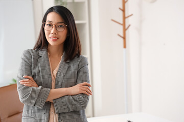 Beautiful Asian businesswoman in stylish eyeglasses in office