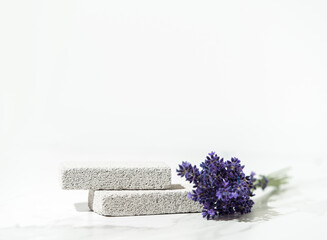 Cosmetics and skin care product presentation scene made with lavender flowers and pumice stone podium.