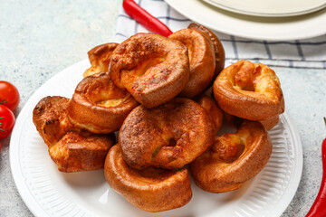 Plate with tasty Yorkshire pudding on light background