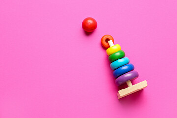 Wooden colorful toy pyramid on pink background. Children's Day celebration