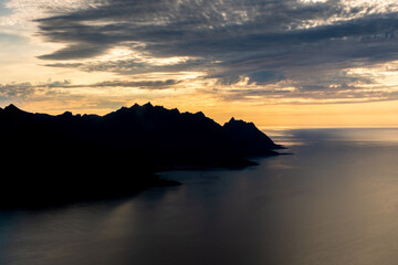 Fototapeta premium Sunset over the Devil's Teeth mountains of Senja Island and the Atlantic Ocean. View from Hesten Mount, Norway