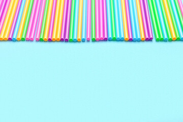 Different plastic straws on blue background