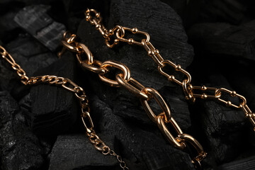 Beautiful chain bracelets on black charcoal, closeup