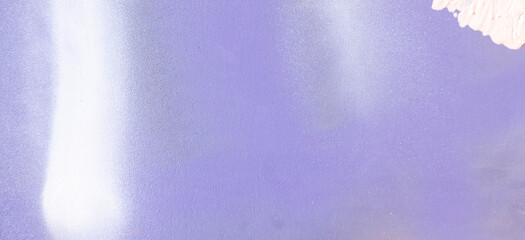 White paint strokes and smudges on purple painted wall background. Abstract wall surface with part...