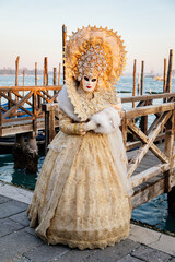 Fototapeta na wymiar Venice, Italy, 11 February 2023: Colorful carnival masks at famous traditional festival on Saint Mark's Square at sunset, Beautiful Elegant Venetian Costume, Woman in white puffy dress with crystals