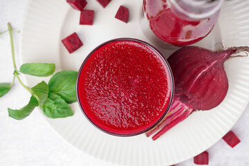 Glass of fresh beetroot juice on light background