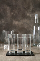 Glasses of vodka on grey background