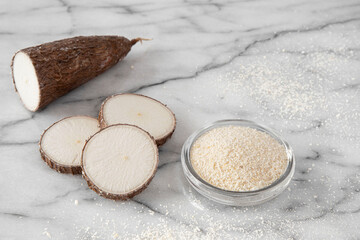 Cassava root and flour on a white background