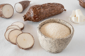Cassava root and flour on a white background