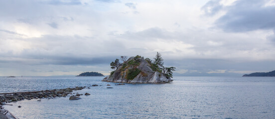 Rocky Island on the West Coast of Pacific Ocean. Cloudy Sunrise.