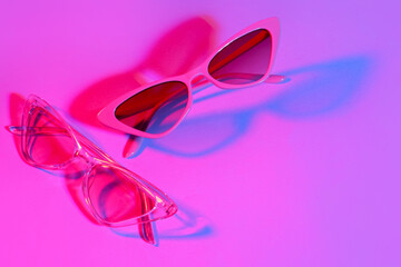 Different stylish sunglasses on pink background
