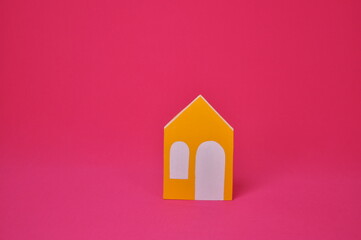 casa pequena amarela em fundo rosa 