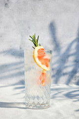 Summer chilled grapefruit cocktail with ice and rosemary sprig. Summer cold drinks. Soda with citrus