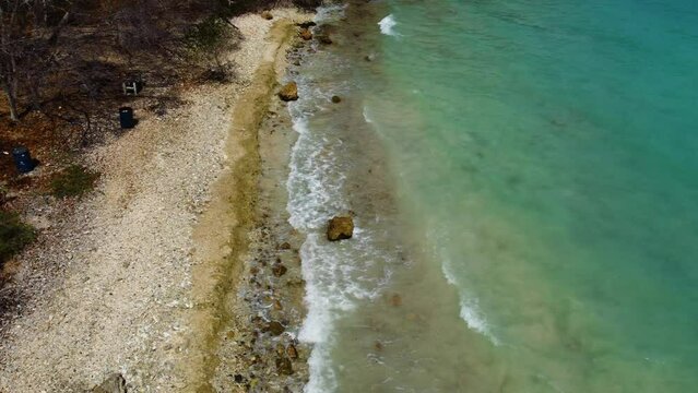 Sunny Caribbean Sea coast with tropical blue water ocean landscape. Flying drone arial shot rocky and sandy beaches and beautiful waves. Perfect holiday travel exotic destination Curacao Aruba Bonaire